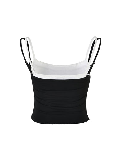 An image showcasing the ADAIR TOP - BLACK/WHITE by TIGERMIST, a color-blocked spaghetti strap tank top featuring adjustable straps. The top section of the garment is white, and the lower section is black. The product is displayed against a white background.