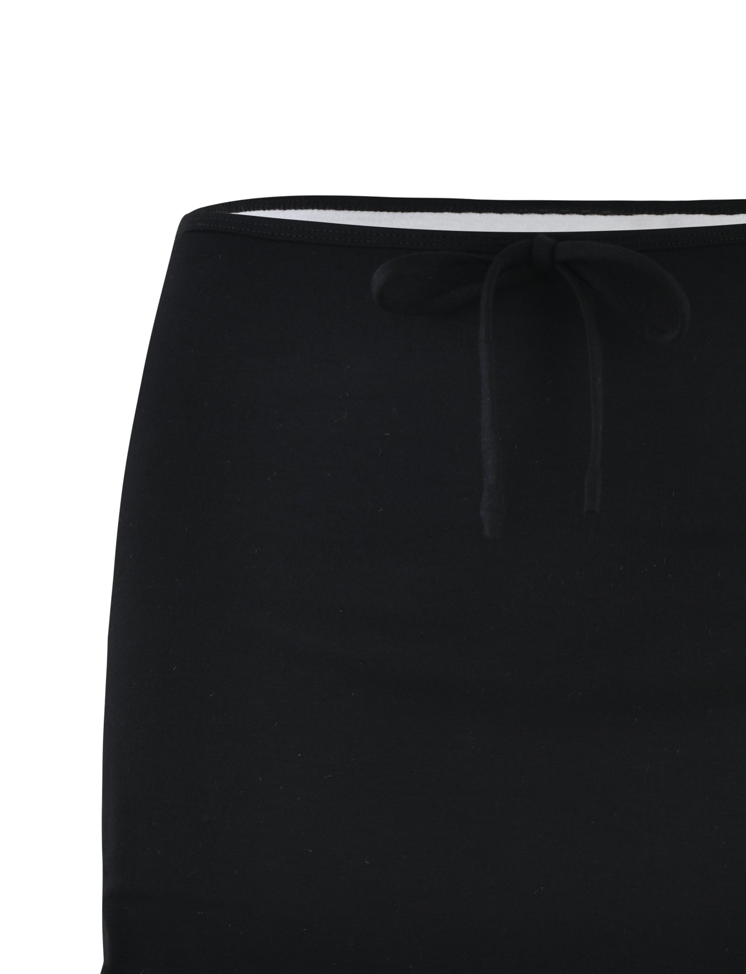 Close-up image of the upper part of the ADAIR SKIRT in black with an elastic waistband. The waistband, featuring a drawstring tied in a simple bow, showcases TIGERMIST's signature style. The fabric appears to be smooth and slightly stretchy, making it suitable for casual wear.