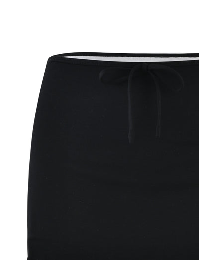 Close-up image of the upper part of the ADAIR SKIRT in black with an elastic waistband. The waistband, featuring a drawstring tied in a simple bow, showcases TIGERMIST's signature style. The fabric appears to be smooth and slightly stretchy, making it suitable for casual wear.
