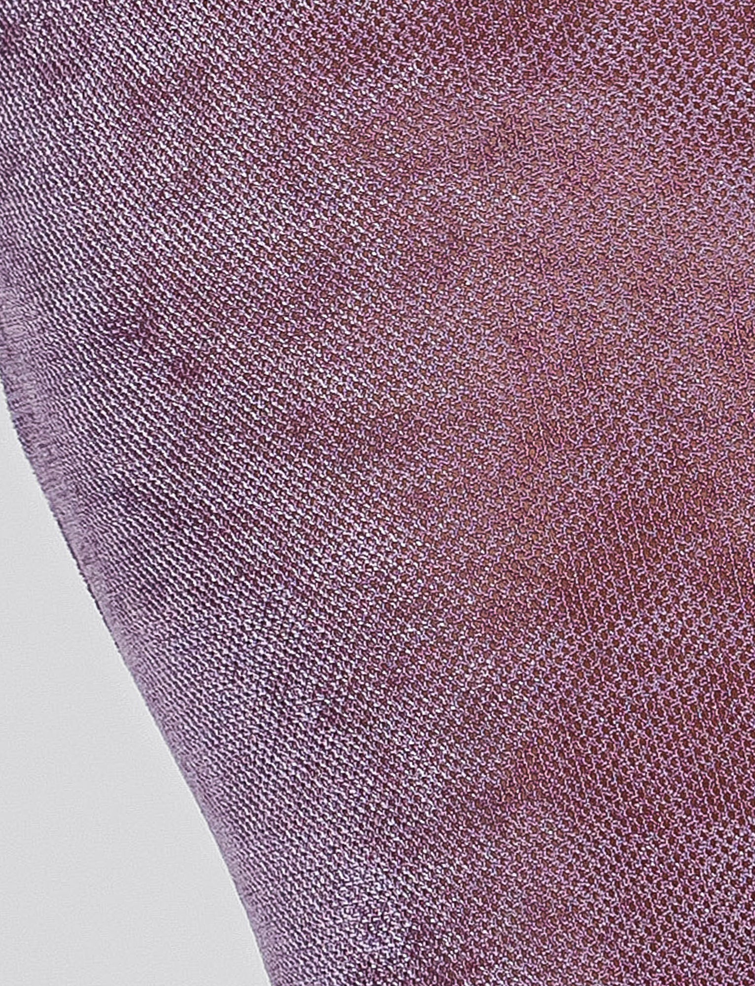 Close-up of the ABRIL DRESS - PURPLE by TIGERMIST, showcasing its textured, knitted surface in a vibrant shade of purple. The finely woven material has a slight sheen, likely due to synthetic fibers, and the intricate pattern and texture add depth and variation in color.